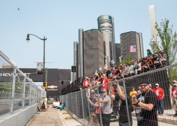 Grand stand fans watching the Detroit Grand Prix with the Renaissance Center in the background