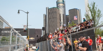 Grand stand fans watching the Detroit Grand Prix with the Renaissance Center in the background