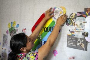 Sam Mena, Policy and Research Intern at We the People-MI, contributes to the diverse narrative of the mixed media mural
