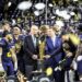 CFP president Bill Hancock, gets ready to present the CFP National Football trophy to the Wolverines after defeating the Huskies