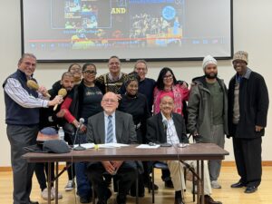 Photo of Mario Grillo (right seated at table)with Bomba group RicanStruction and Jorge Chinea from Center for Latino Studies and Ollie Johnson from African American Studies