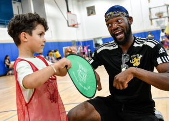 DCFC Youth Coach Duane Daniels cools down with a young player.