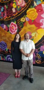 Art Appraiser Isabelle Weiss and Muralist Elton Monroy Duran pose with the mural, which is the centerpiece of CJ’s Lounge on the first floor of the Brooke on Bagley