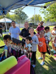 Commander Shelley Holderbaum surrounded by neighborhood kids