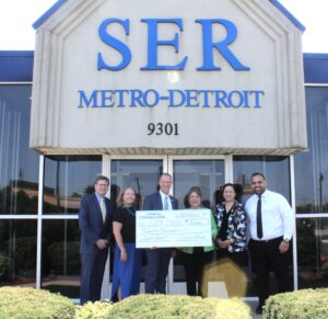 Steve Davis, Michigan Market President of Comerica Bank, pictured third from left, presents a check for $20,000 to SER Metro-Detroit leadership, from left, David Cunningham, Ann Leen, Eva Garza Dewaelsche and Veronica Sanchez Peavey. Pictured at far right, Hassan Melhem, Vice President - External Affairs, National Middle Eastern American Business Development at Comerica