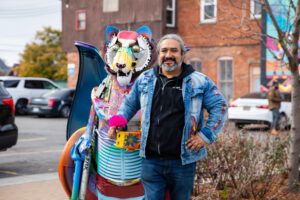 Local visual artist Elton Monroy Duran proudly displays one of five Alebrijes sculptures unveiled on the Bagley Streetscape in Mexicantown. Photo by Alejandro Ugalde