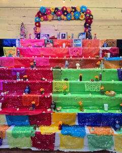 Food and pictures of loved ones that have passed are placed on the “ofrenda” outside in preparation for the inaugural Dia de los Muertos Tianguis/Festival at La Jalisciense Supermercado & Taqueria in Southwest Detroit. Photos from Facebook.