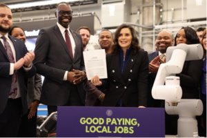 Gov. Gretchen Whitmer holds up the Michigan Innovation Fund bills signed into law this week flanked by Rep. Alabas Farhat, far left, Lt. Gov. Garlin Gilchrist, left, and Rep. Tyrone Carter, back row center