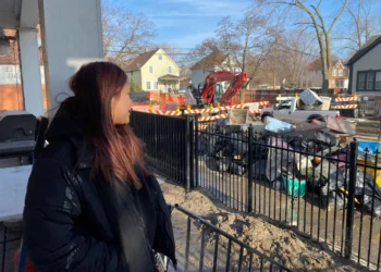 Yajaira Martinez, 20, looks out at the site of the main water break from her home in Southwest Detroit. Darcie Moran