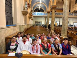 Members of Moyocoyani Izel Ballet Folklorico Dance Troupe posing in the pews of St. Hedwig before Wednesday night musical event