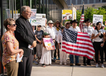Fr. David Buersmeyer y Mrs. Judith Brooks de Strangers No Longer / hablan a los participantes de la procesión frente a la oficina de campo de ICE en Detroit / address procession participants in front of the field office of ICE in Detroit. Foto de/Photo by Valaurian Waller | Detroit Catholic