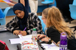 Detroit International Academy for Young Women junior Aysha Uddin, left, and University of Michigan freshman Willow Lagrou, right, learn about story structure during a lesson at Wayne State University’s Manoogian Hall on Wednesday, July 9, 2025