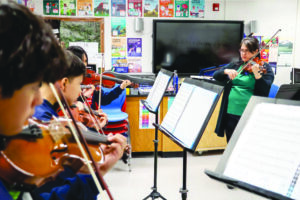 Teaching Artist Dr. Saraí Aboites accompanying students during ensemble rehearsal at the Cesar Chavez Academy Upper Elementary Classroom on December 5, 2025