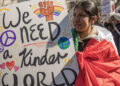 Protester holds a sign stating “We need a kinder world” at No Kings Demonstrations