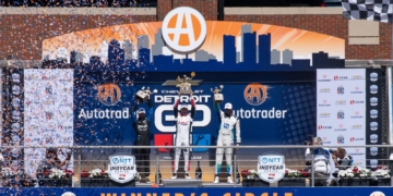 Alex Palou (Spain, #10) celebrates his first place victory at the 2026 Detroit Grand Prix alongside second place Kyle Kirkwood (USA, #27), and third place Graham Rahal (USA, #15) on top of the winners circl