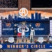 Alex Palou (Spain, #10) celebrates his first place victory at the 2026 Detroit Grand Prix alongside second place Kyle Kirkwood (USA, #27), and third place Graham Rahal (USA, #15) on top of the winners circl